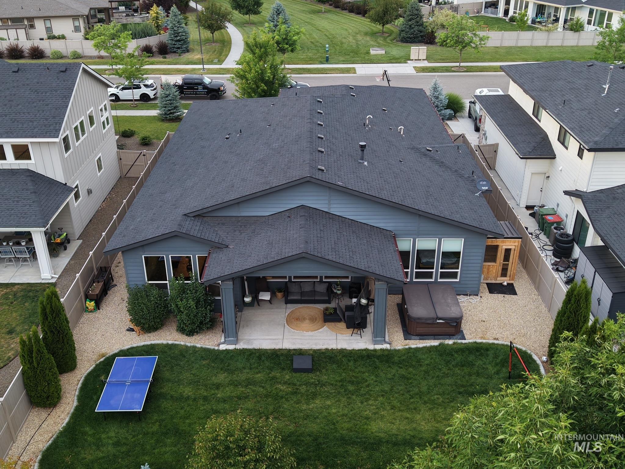 Expansive backyard featuring a manicured lawn, gravel perimeter, and mature trees