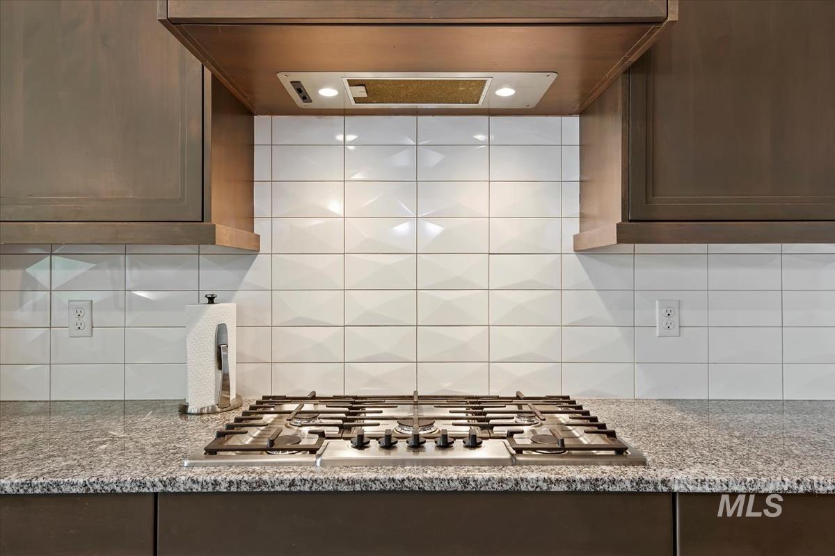 Stainless steel gas cooktop set within a granite countertop