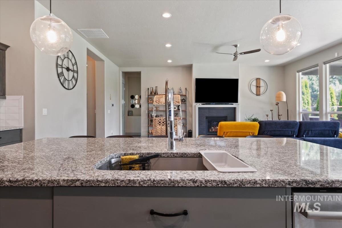 Spacious kitchen island featuring a granite countertop with an undermount sink and a gooseneck faucet