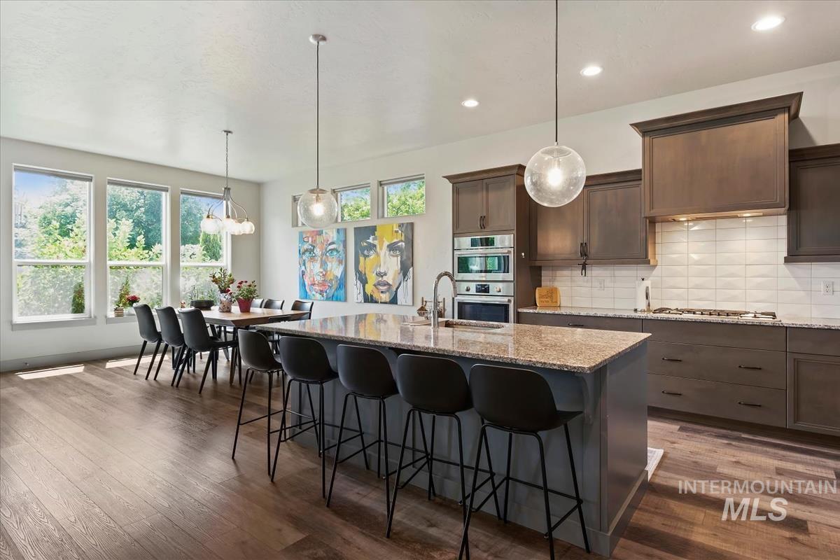 Open-concept kitchen and dining area featuring wood-finish flooring
