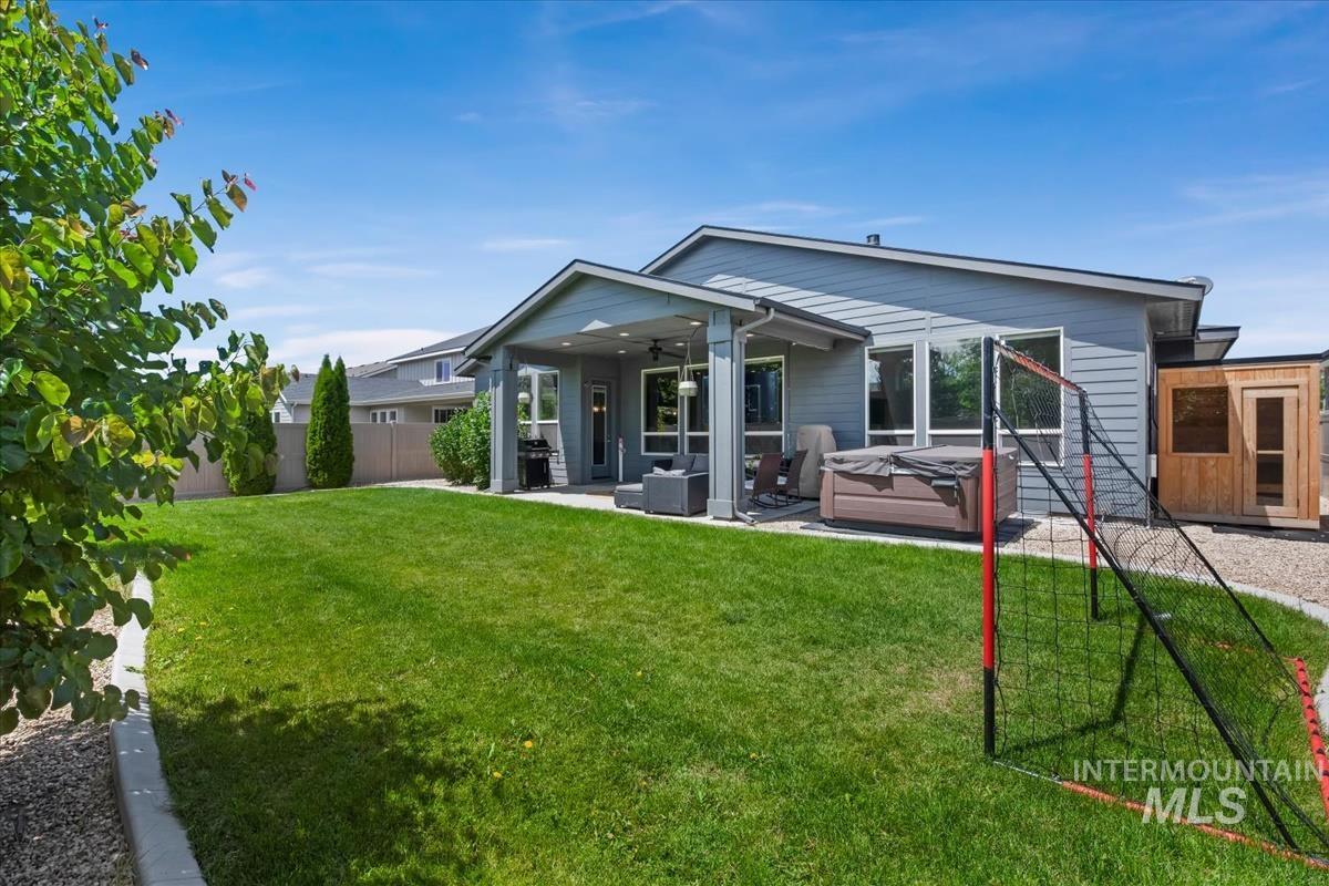 Expansive backyard with a manicured lawn, covered patio, and gravel hardscaping
