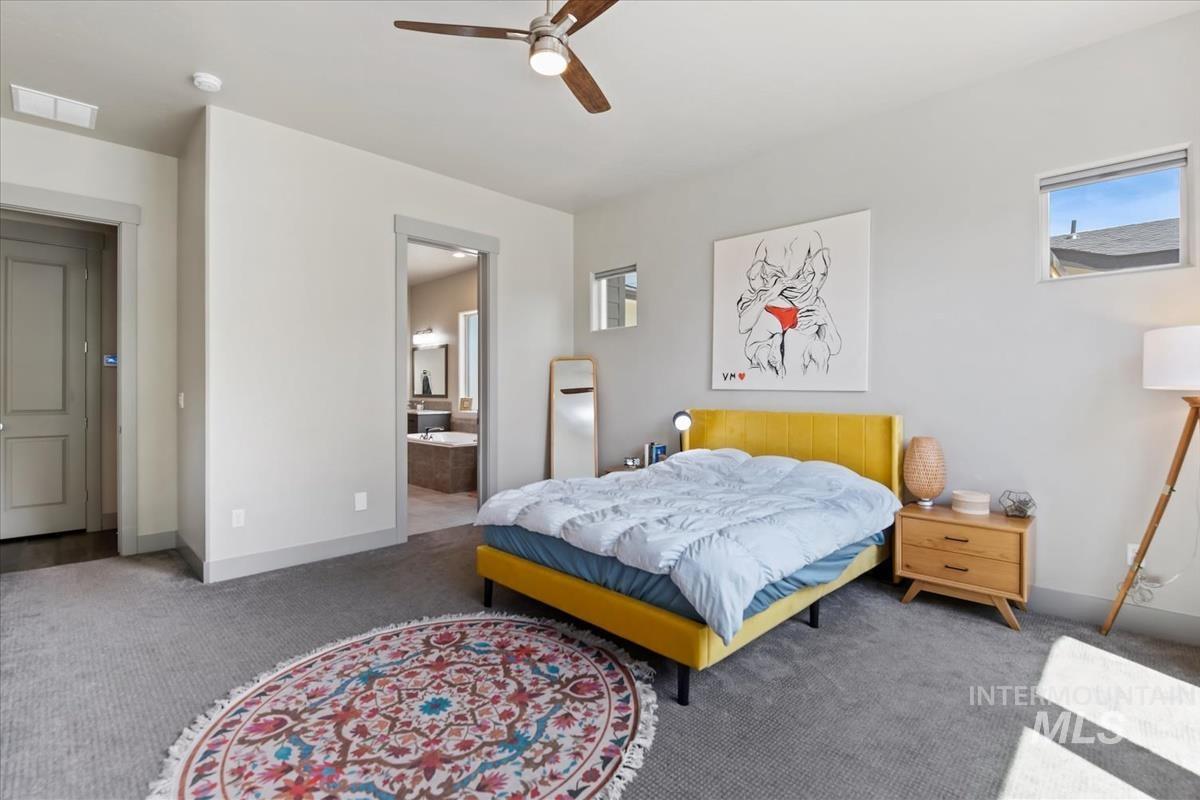 Carpeted bedroom with a ceiling fan, recessed lighting, and multiple windows