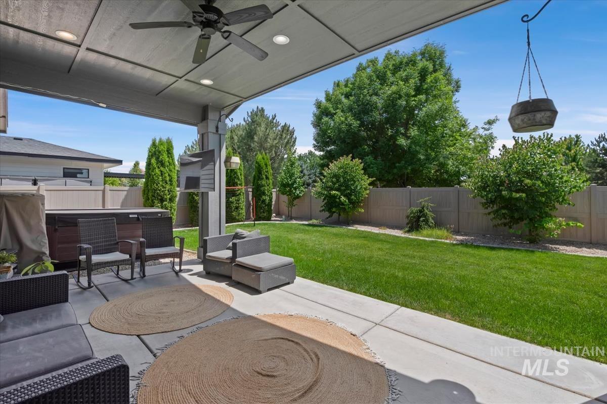 Covered patio featuring an outdoor ceiling fan, recessed lighting, concrete flooring, and a built-in spa