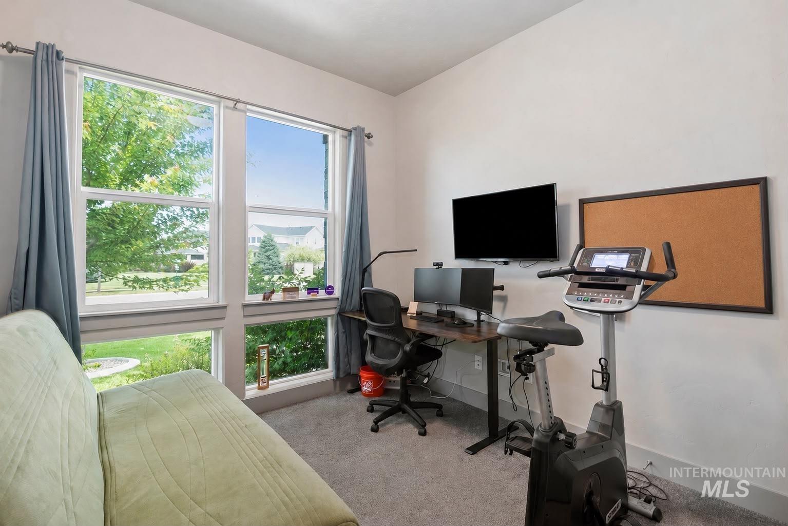 Bright room featuring a large window array, neutral wall color, and gray carpeting