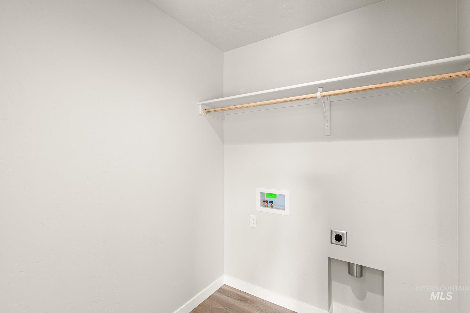 Laundry room featuring wood finished floors, electric dryer hookup, and washer hookup