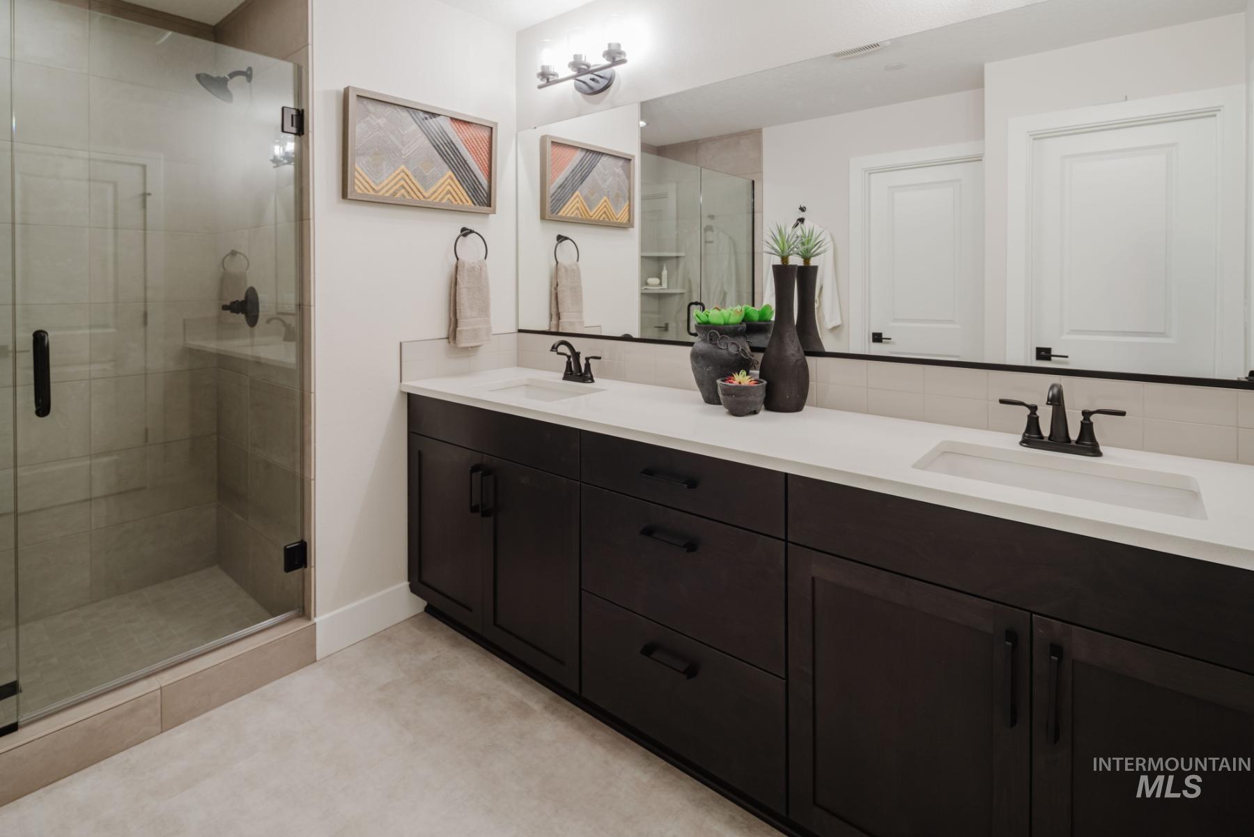 Bathroom featuring double vanity and a stall shower