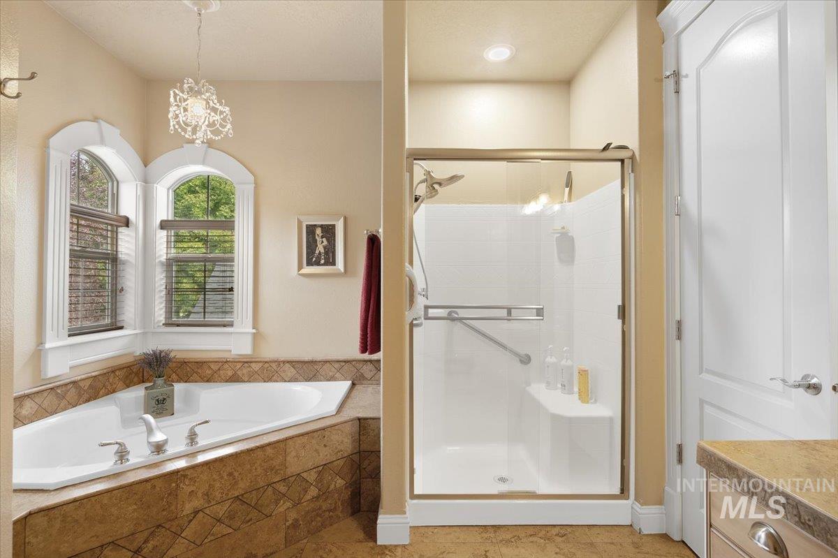 Full bath featuring a shower stall, a bath, vanity, and light tile patterned floors