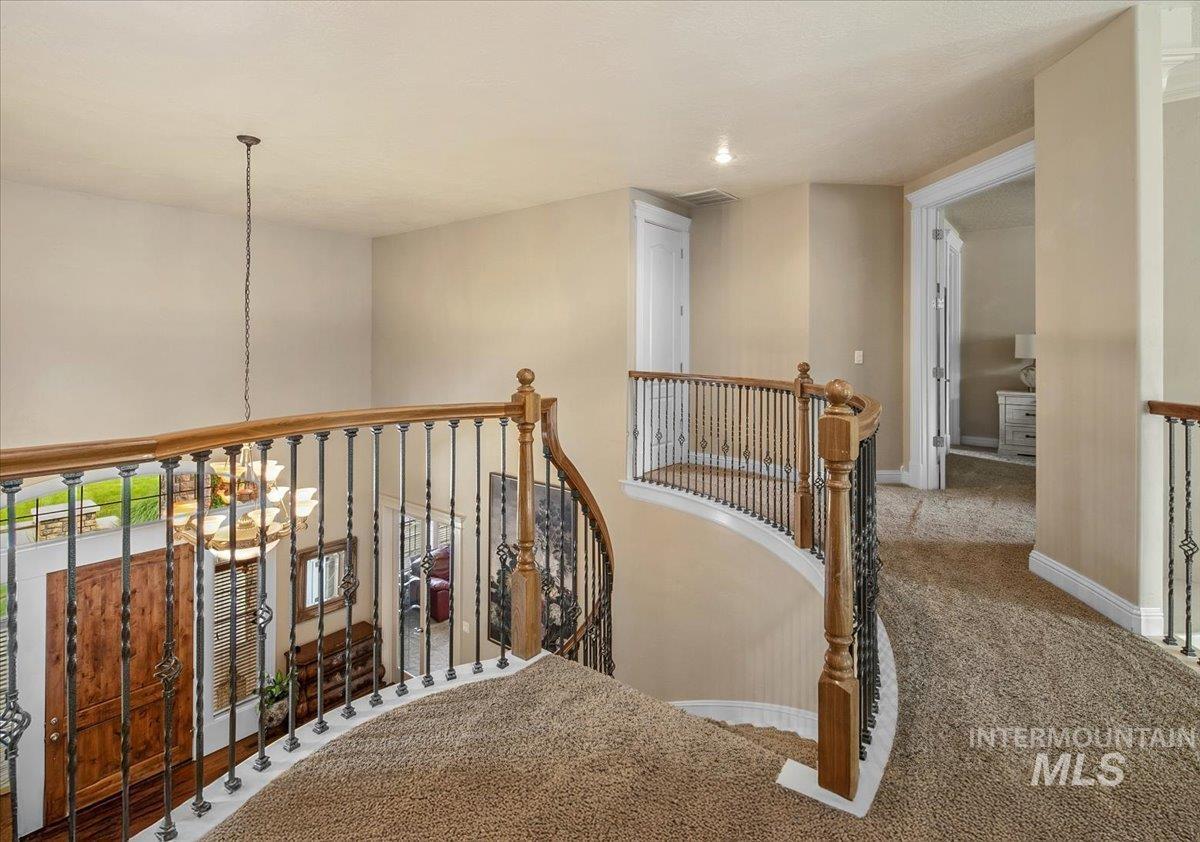 Corridor with carpet, an upstairs landing, and a chandelier