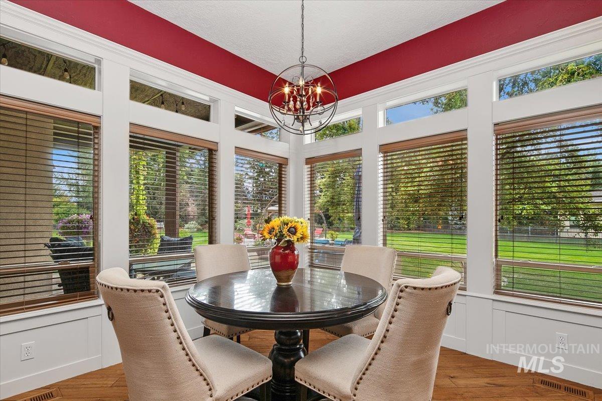 Sunroom featuring wood finished floors, a chandelier, and a textured ceiling