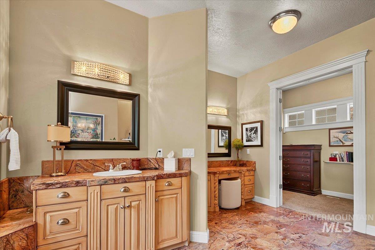 Full bath featuring vanity, a textured ceiling, and a closet