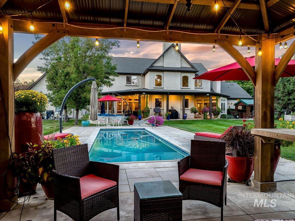 Rear view of house featuring a patio, an outdoor pool, a yard, and stucco siding