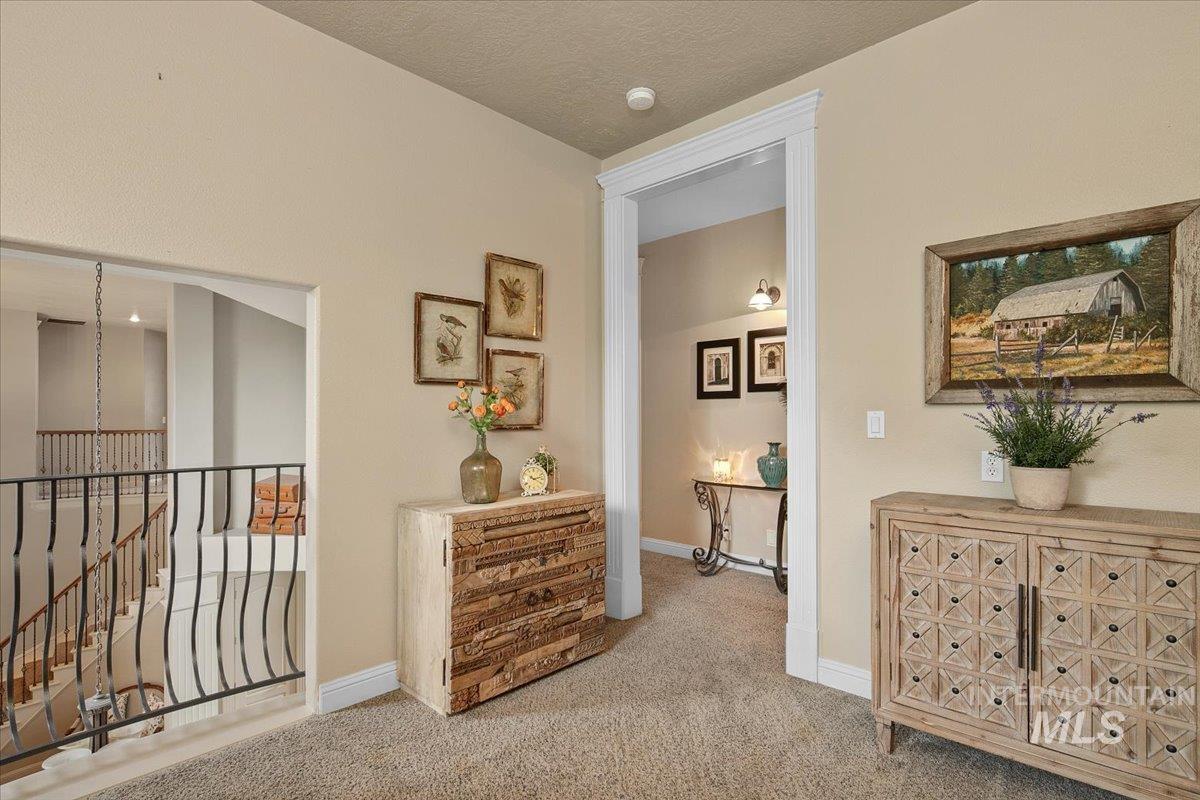Hall featuring carpet and an upstairs landing