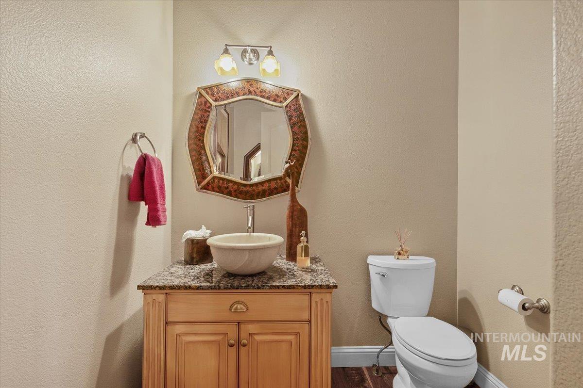 Bathroom featuring a textured wall, vanity, and dark wood-type flooring
