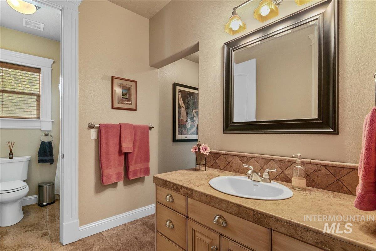 Bathroom with vanity, backsplash, and light tile patterned floors