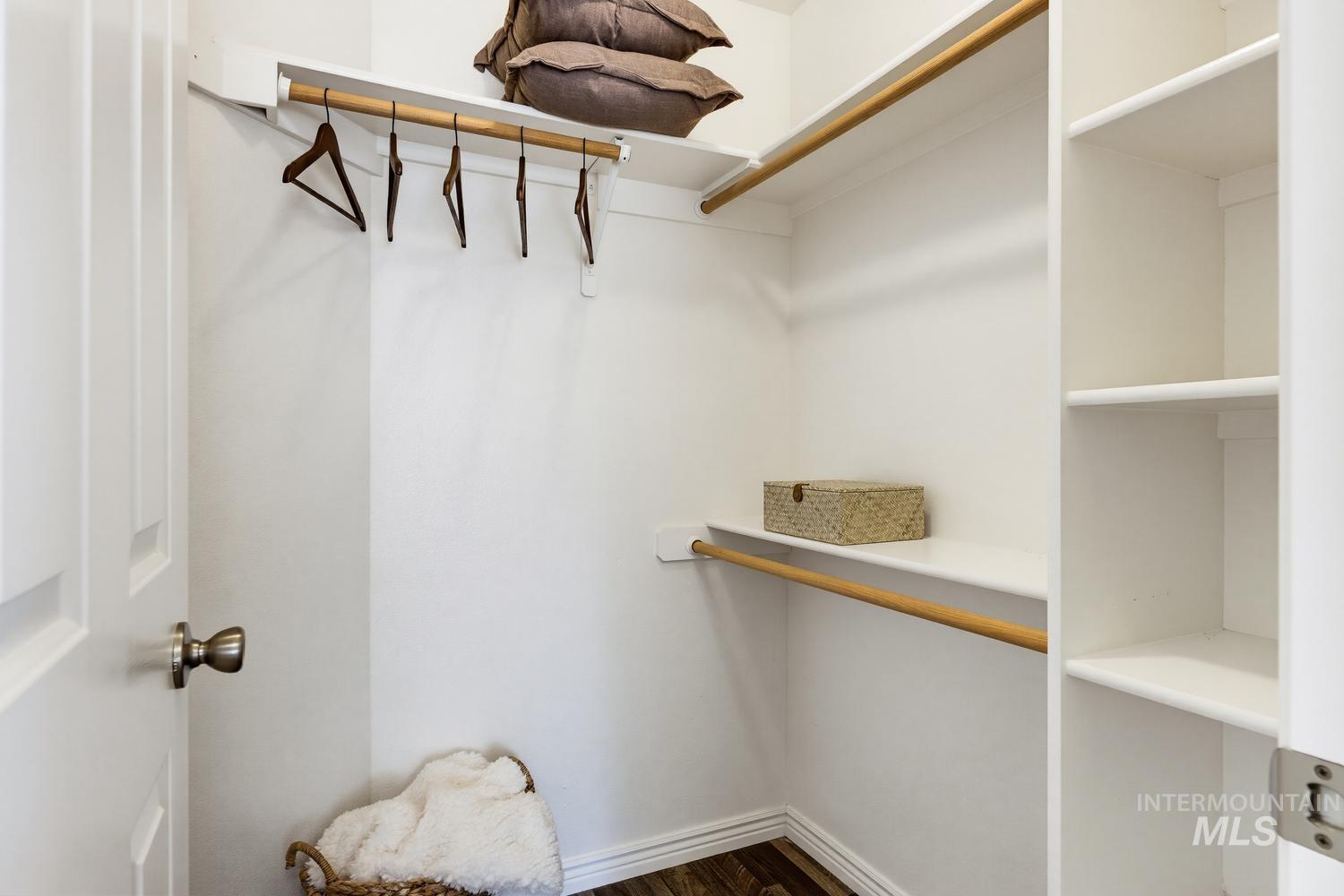 White closet interior featuring multiple storage shelves and hanging rods