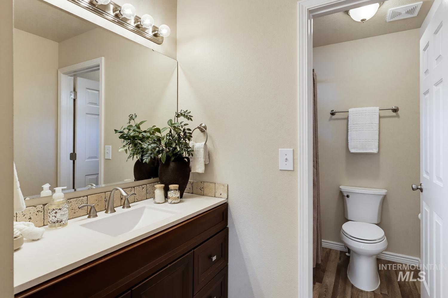 Vanity with a white countertop, undermount sink, and brushed nickel faucet