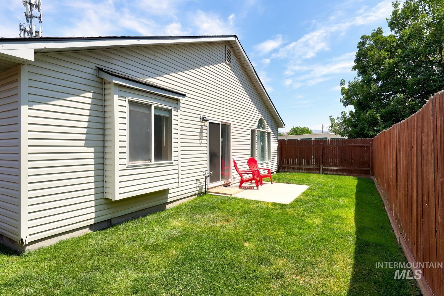 Expansive backyard featuring a manicured lawn, a concrete patio, and a privacy fence