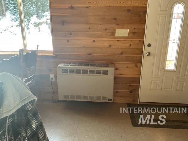 Sauna / steam room with wooden walls, tile patterned floors, and healthy amount of natural light