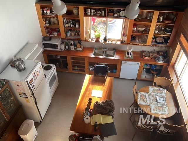 Kitchen featuring healthy amount of natural light, white dishwasher, wood counters, and light flooring