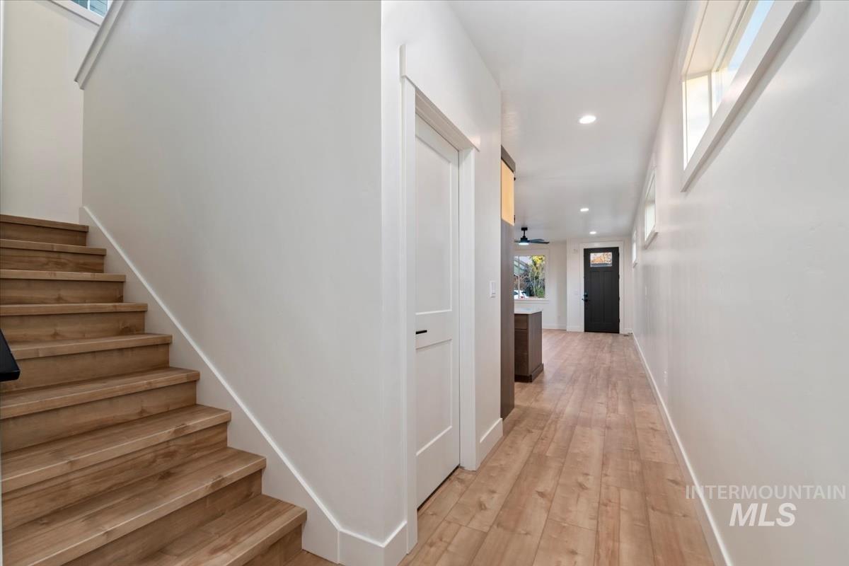 Hallway featuring stairway, recessed lighting, and light wood-style floors