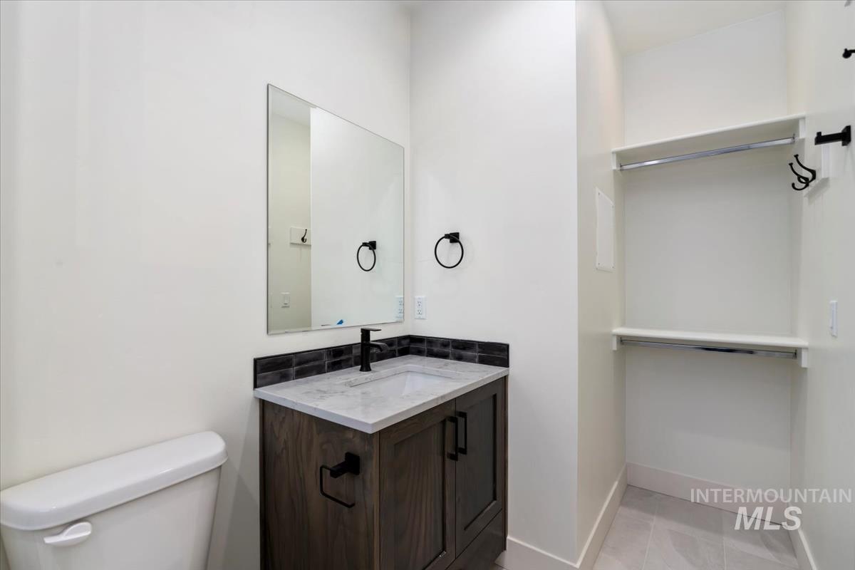Half bath featuring vanity and light tile patterned floors