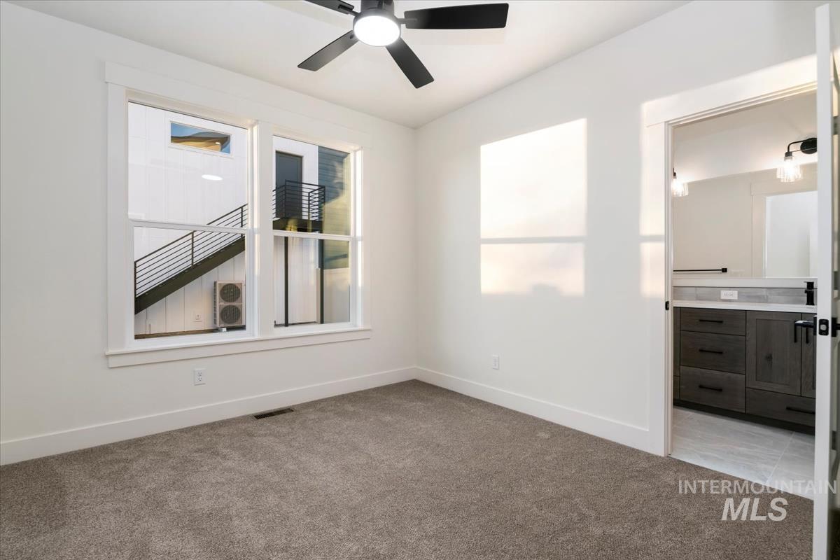 Unfurnished room featuring light colored carpet and a ceiling fan