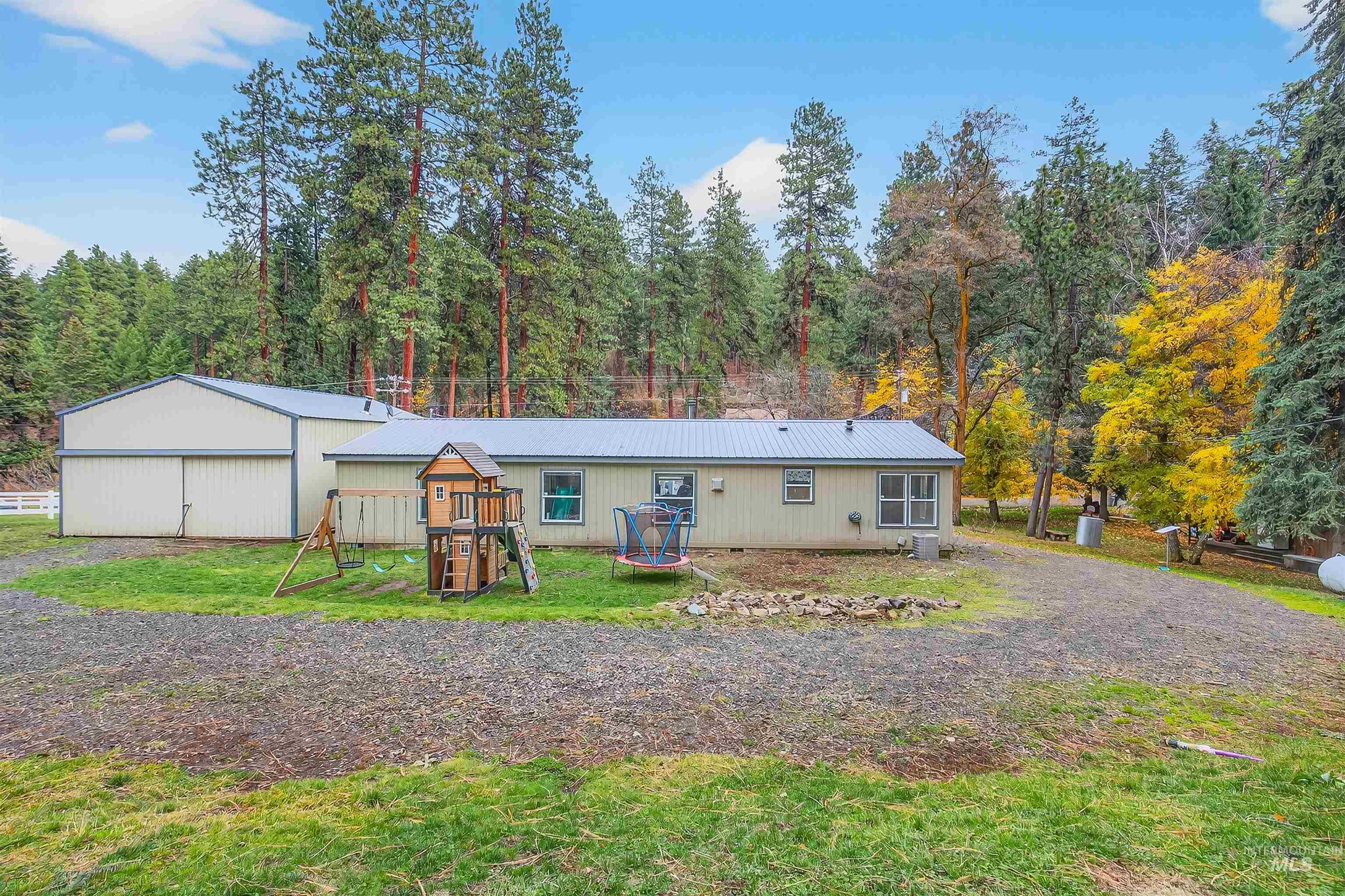 View of front of house featuring a playground, a front lawn, a trampoline, and a metal roof