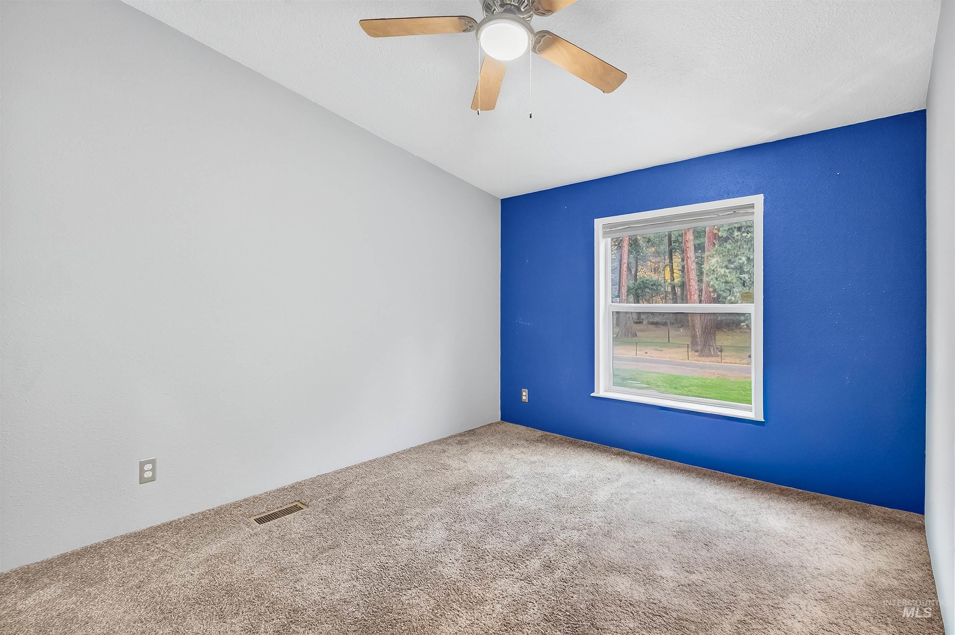 Carpeted empty room featuring ceiling fan