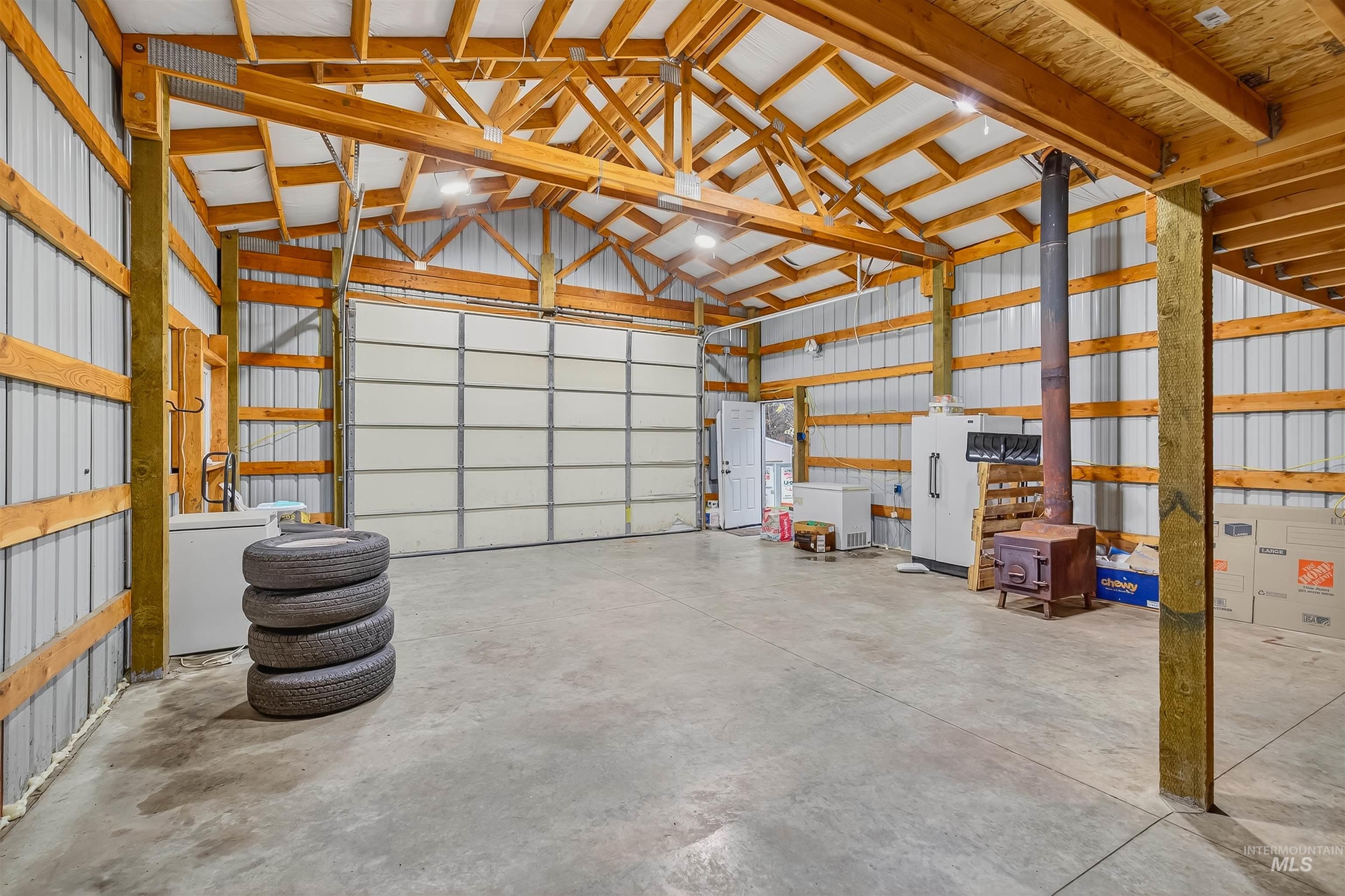 Garage featuring metal wall and freestanding refrigerator