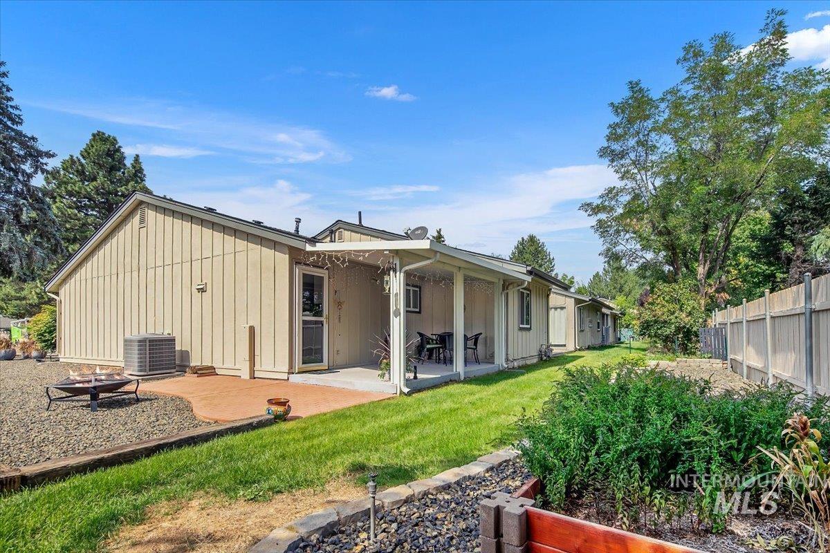 Rear view of house with a patio, board and batten siding, and an outdoor fire pit