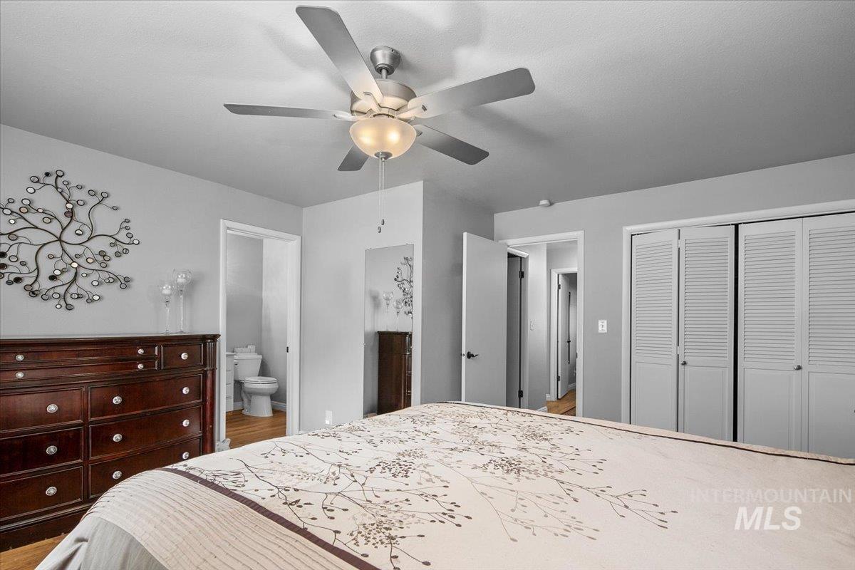 Bedroom with a closet, a ceiling fan, and ensuite bath