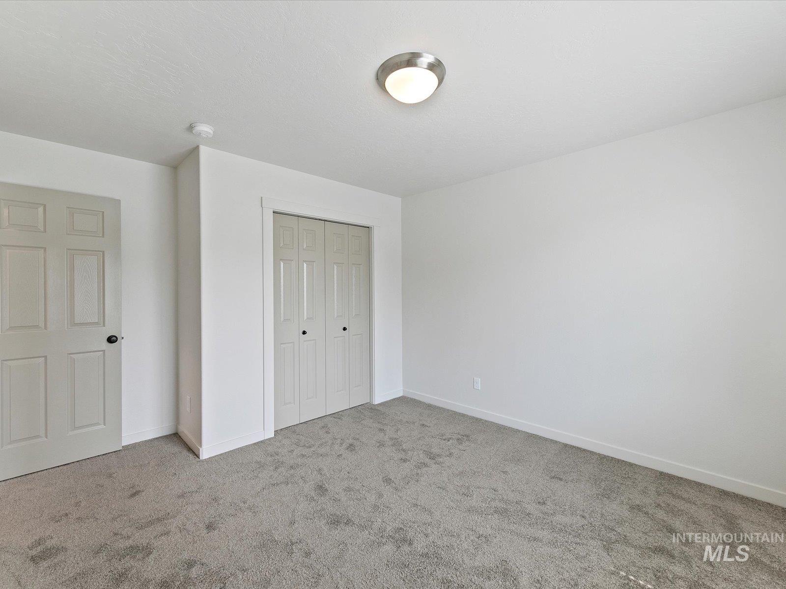 Unfurnished bedroom with carpet flooring and a closet