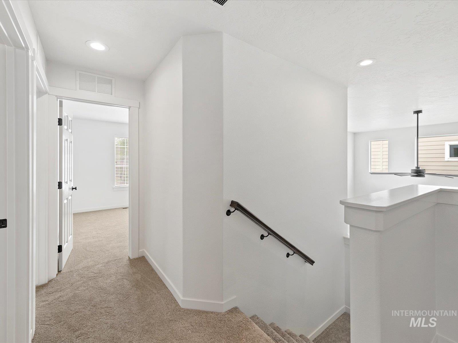 Stairs with carpet and recessed lighting