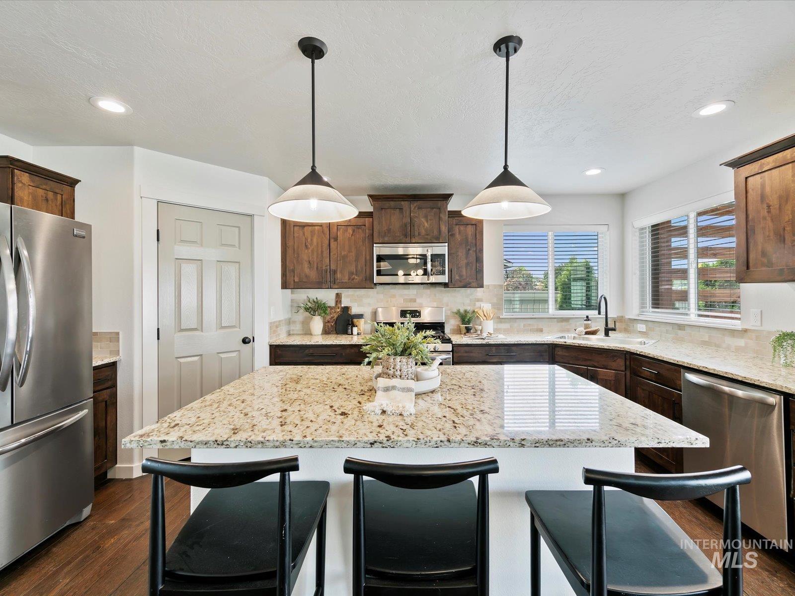 Kitchen featuring a kitchen bar, tasteful backsplash, appliances with stainless steel finishes, dark brown cabinets, and recessed lighting