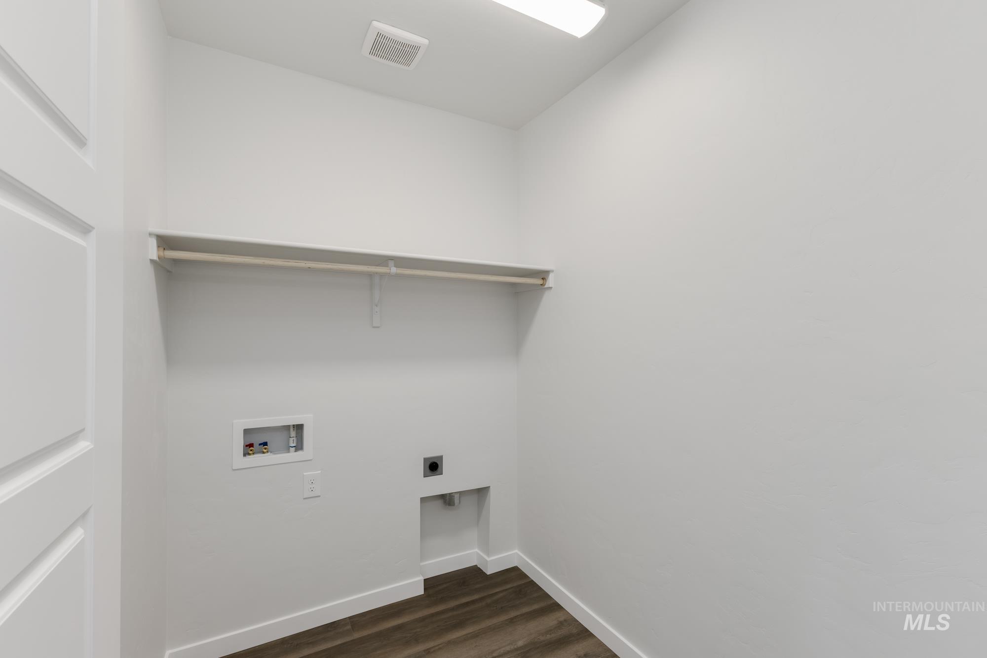 Laundry room with dark wood-style flooring, hookup for a washing machine, and hookup for an electric dryer