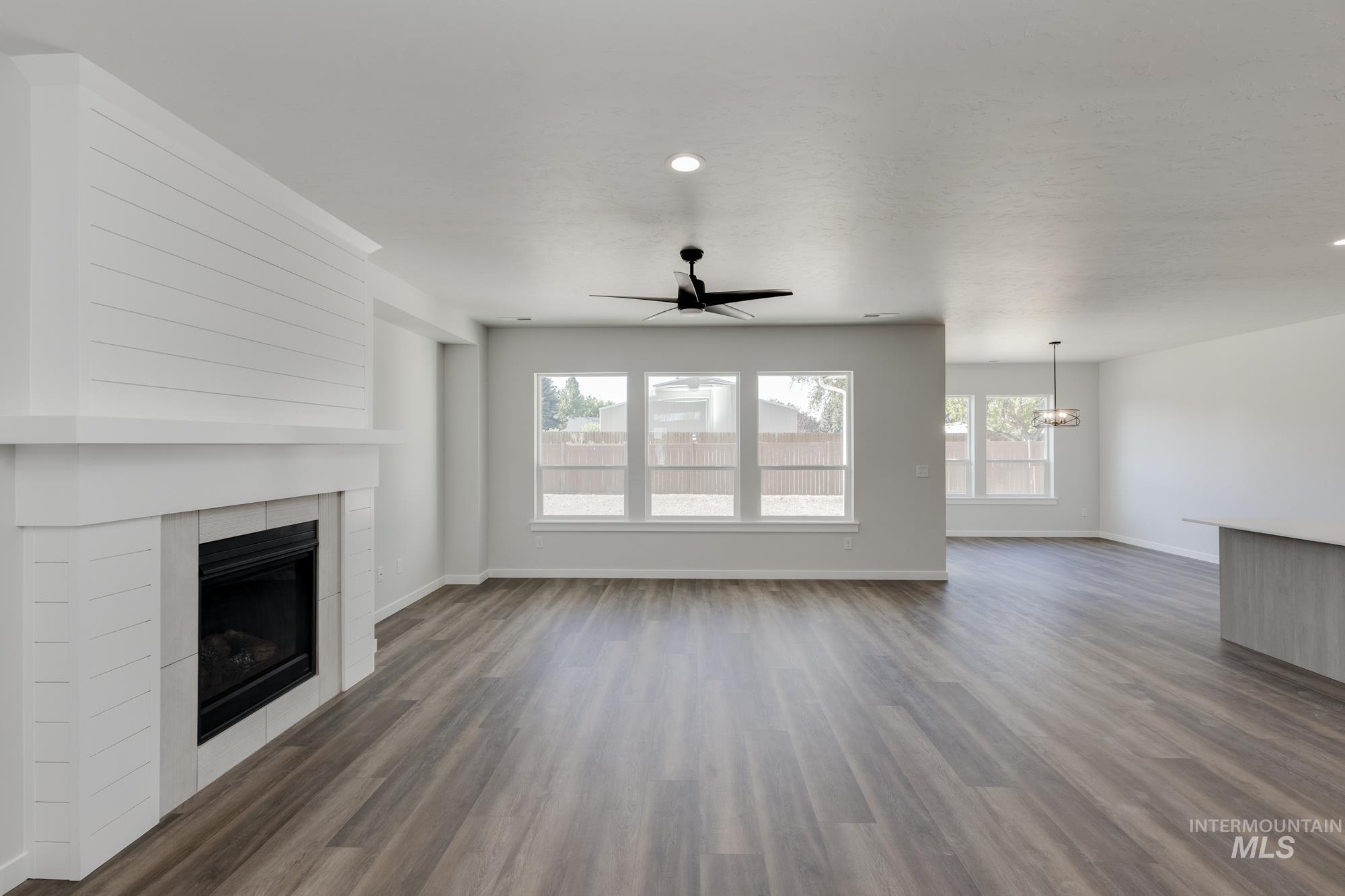 Unfurnished living room with a ceiling fan, recessed lighting, a fireplace, and wood finished floors