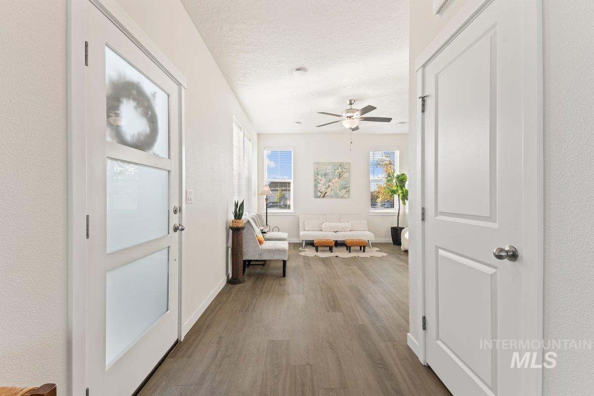 Corridor with wood finished floors and a textured ceiling