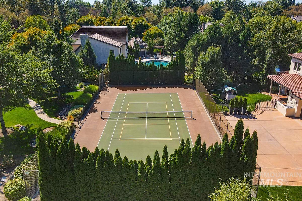 View of tennis court with a forest view