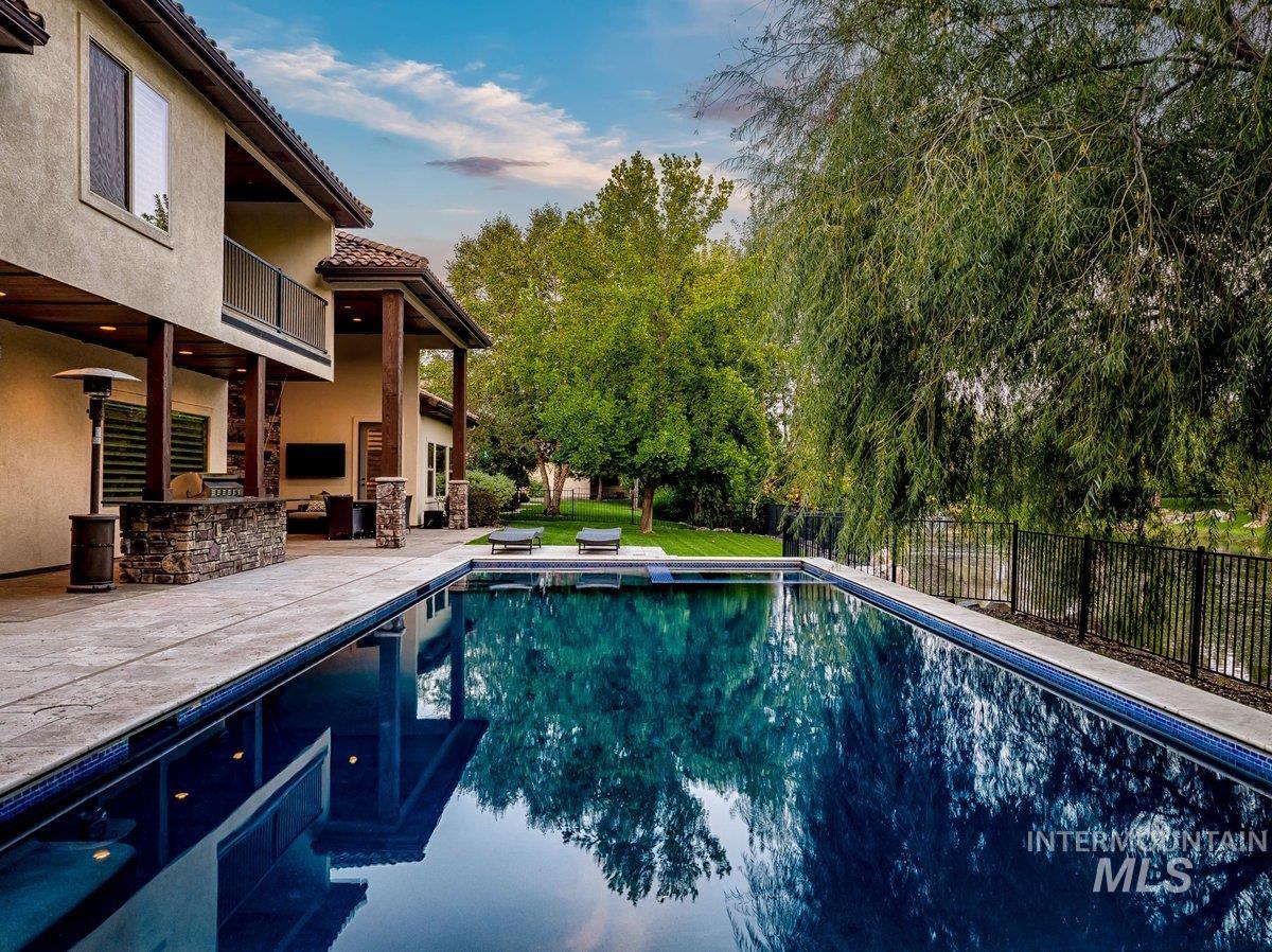 View of swimming pool with a patio area, area for grilling, and view of scattered trees