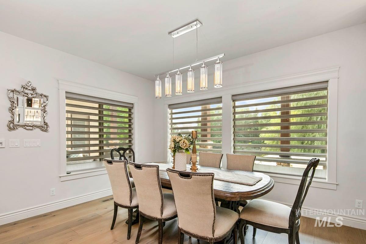 Dining space with light wood-type flooring and rail lighting