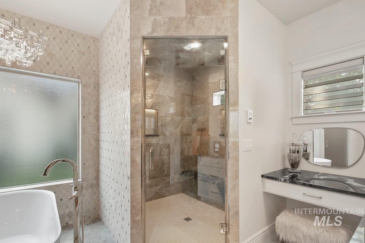 Bathroom with a stall shower, a soaking tub, and vanity