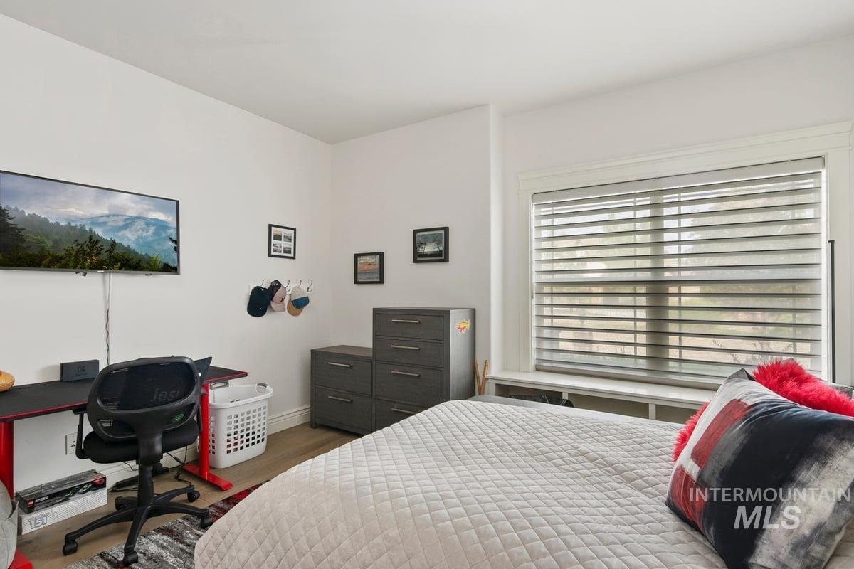 Bedroom with dark wood-style floors and an office area