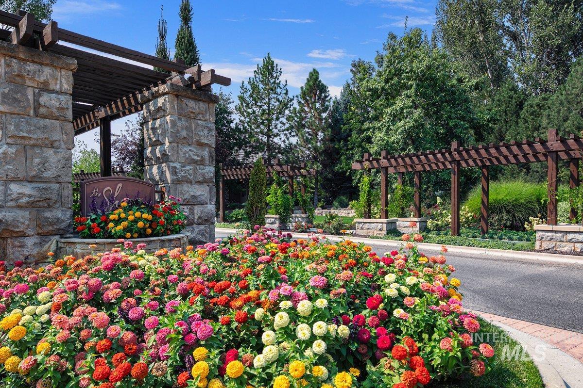 Community sign featuring a pergola and a patio area