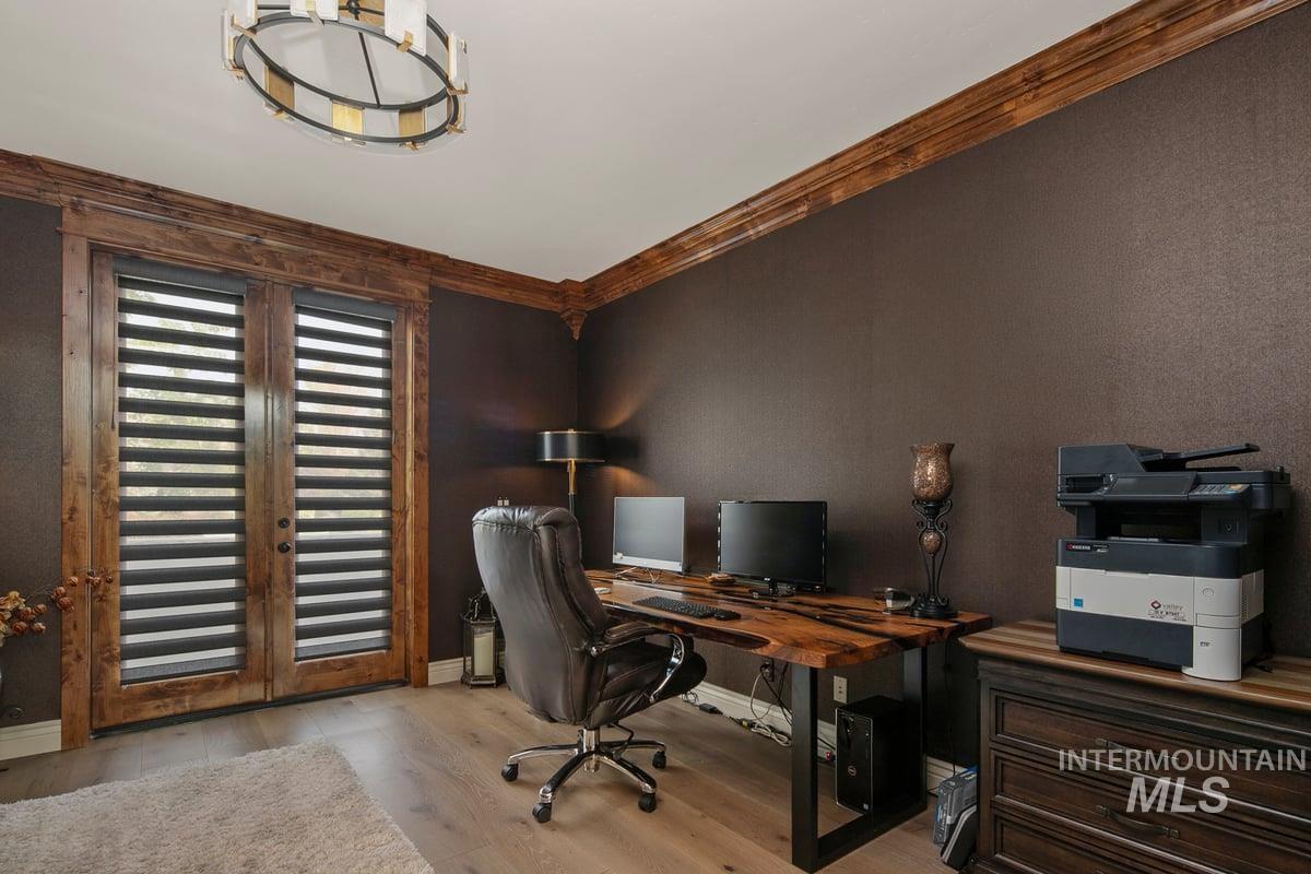 Office area with light wood-style flooring and ornamental molding