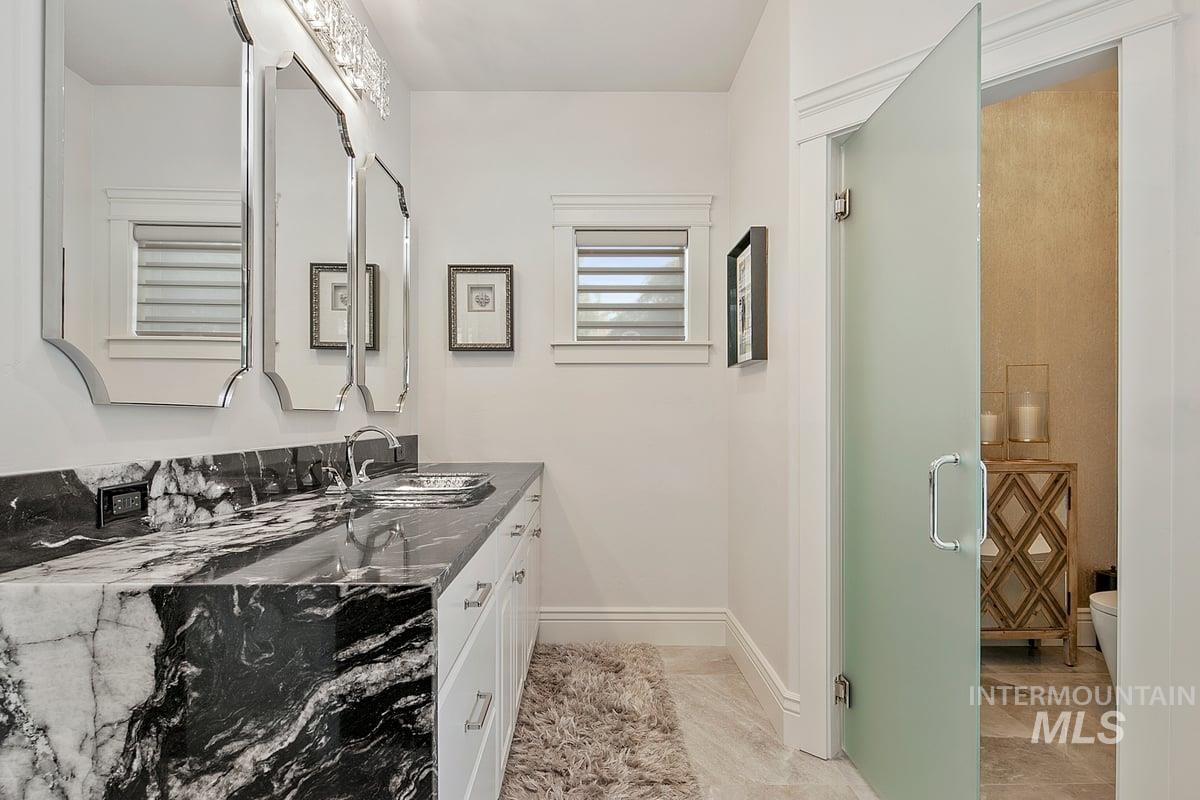 Full bathroom with vanity and baseboards