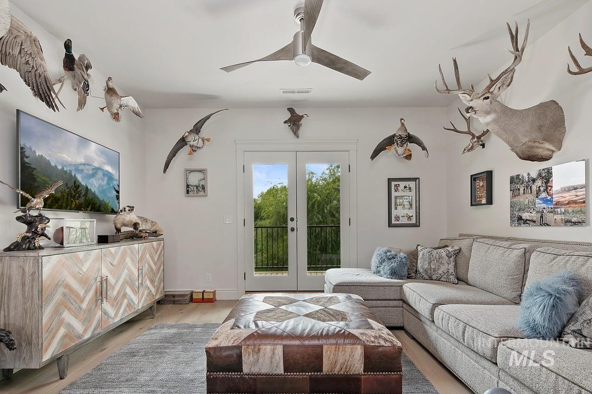 Living room with wood finished floors, french doors, and ceiling fan