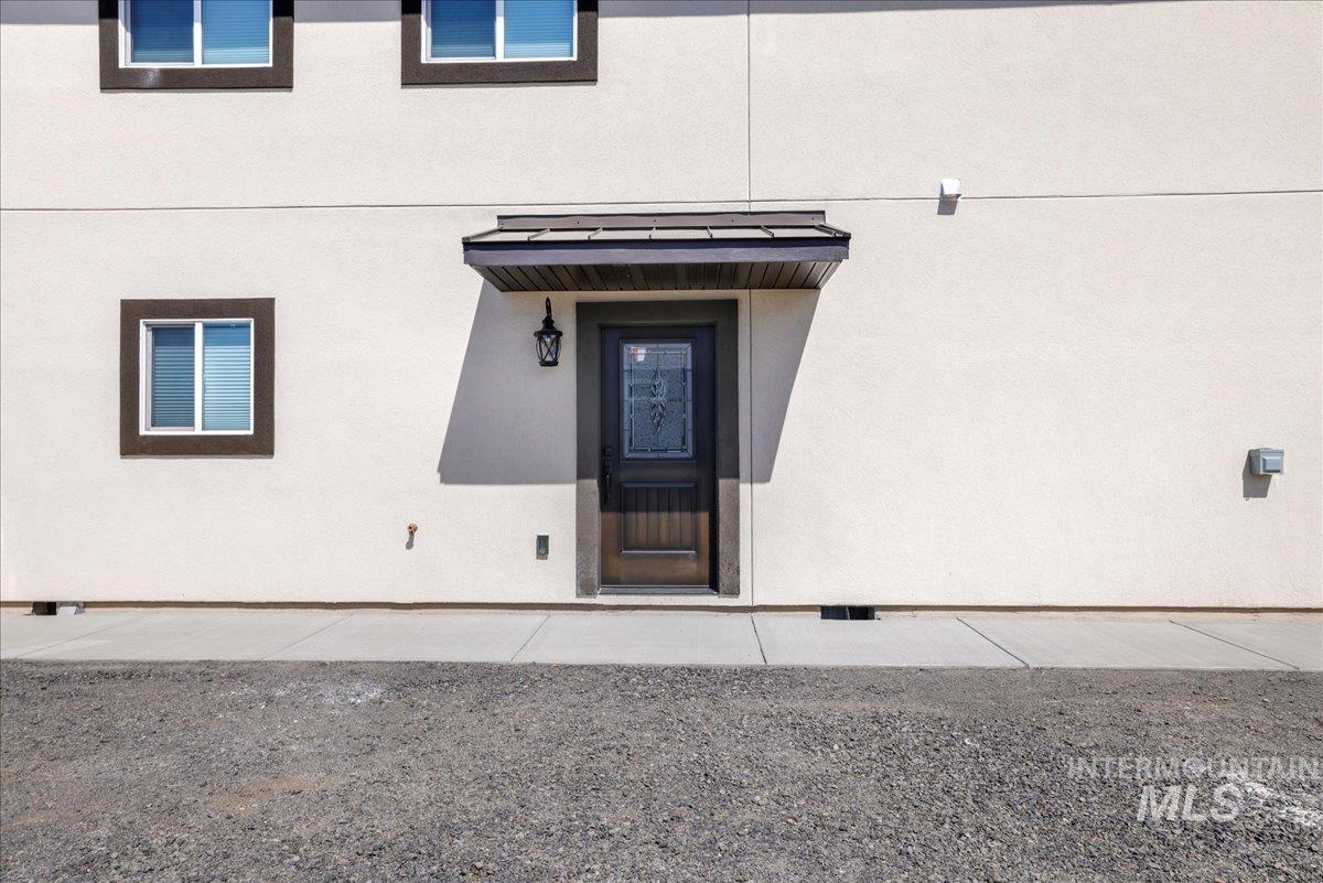 Doorway to property with stucco siding