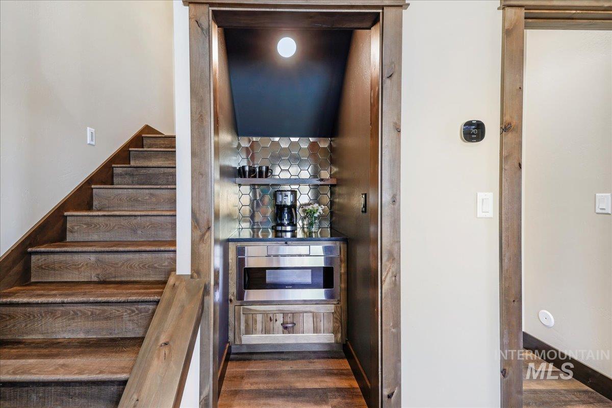 Staircase with wood finished floors and baseboards