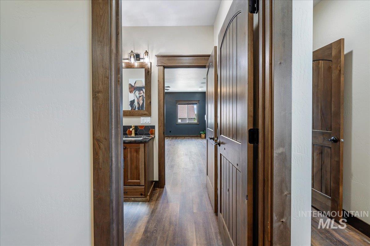 Hallway with dark wood-style flooring and baseboards