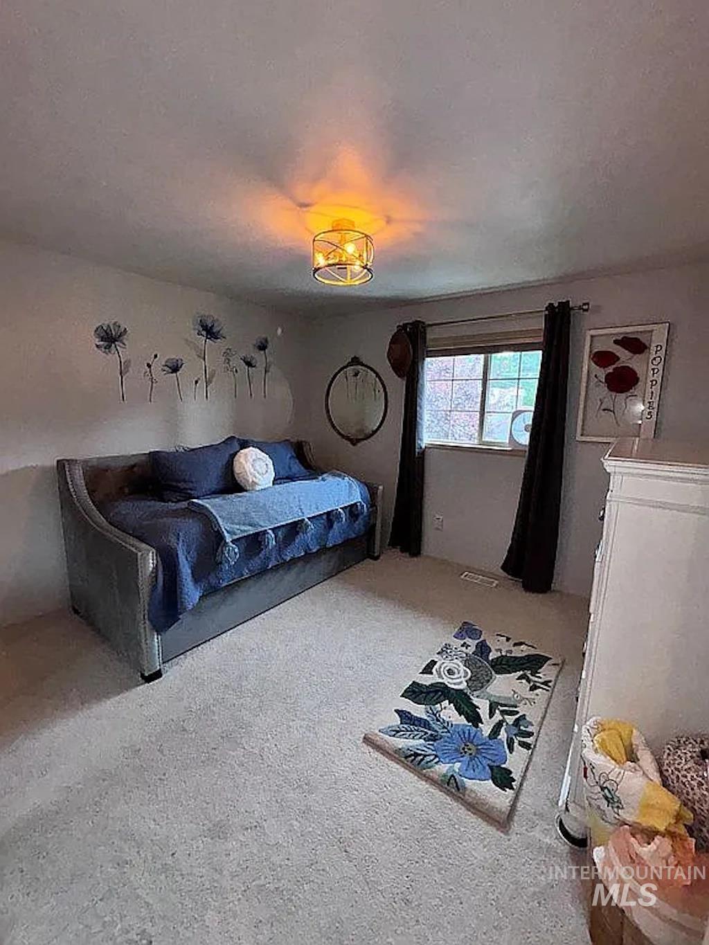 Carpeted room featuring a modern ceiling light fixture and a window with blinds